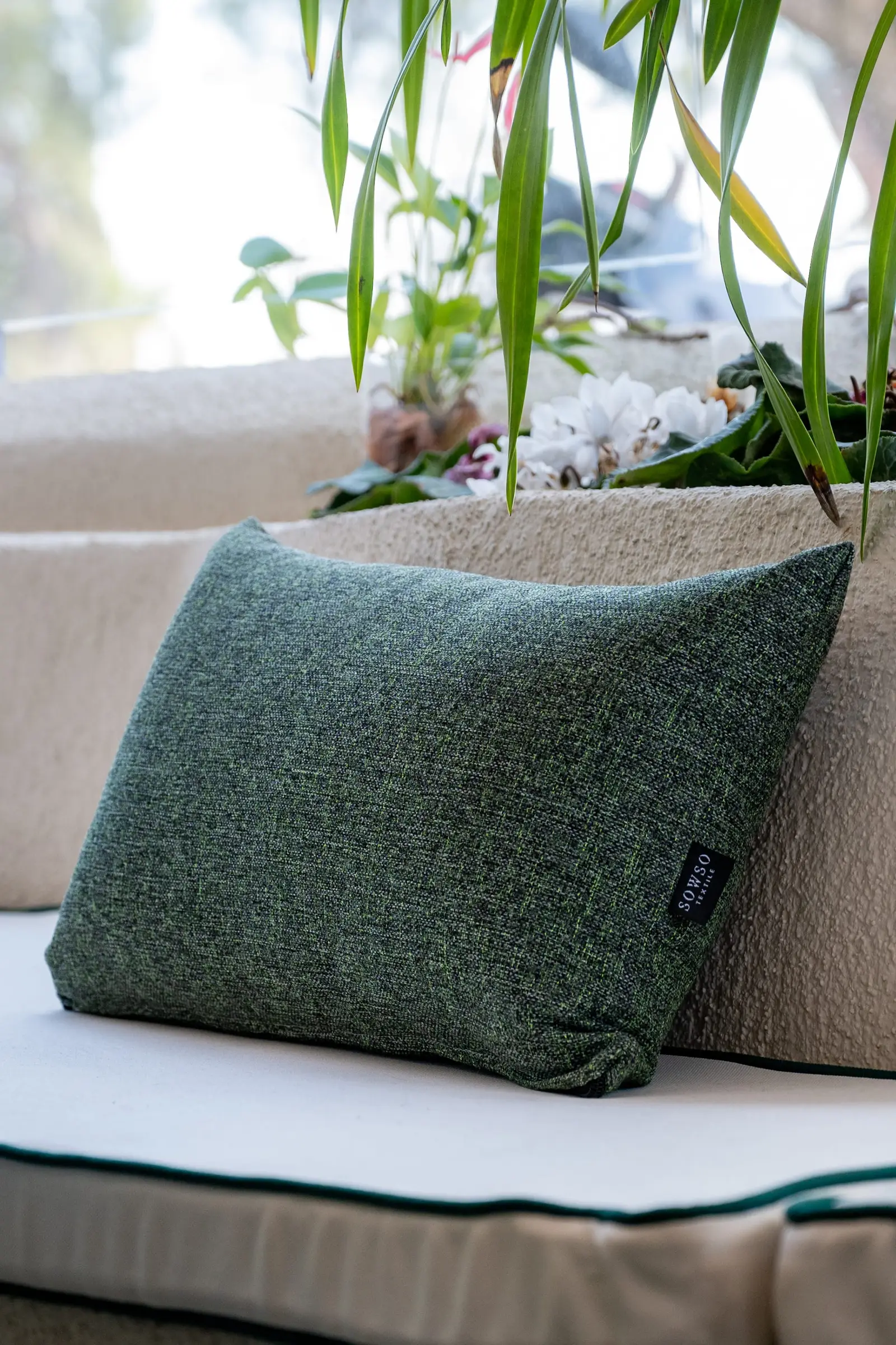 Yeşil dokuma yastık, kenarında SOWSO Textile etiketi